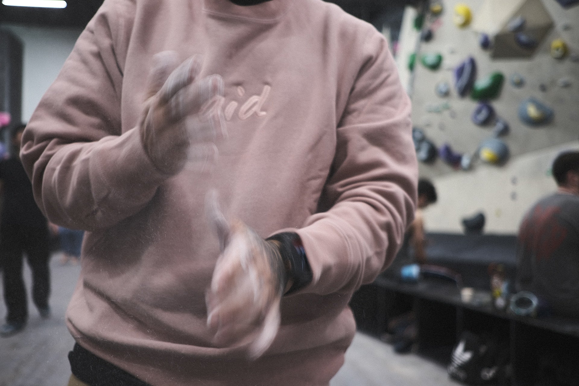 Man wearing the Warm-Up Crew by Aid in a climbing gym