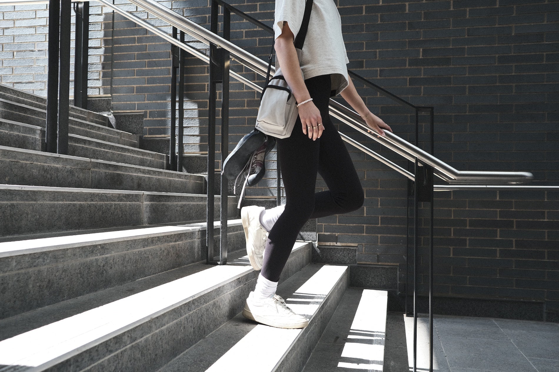 Woman walking down stairs wearing the Crop Top by Aid Climbing Company