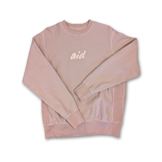 Pink Aid crew neck with 'aid' embroidered text, on a white background